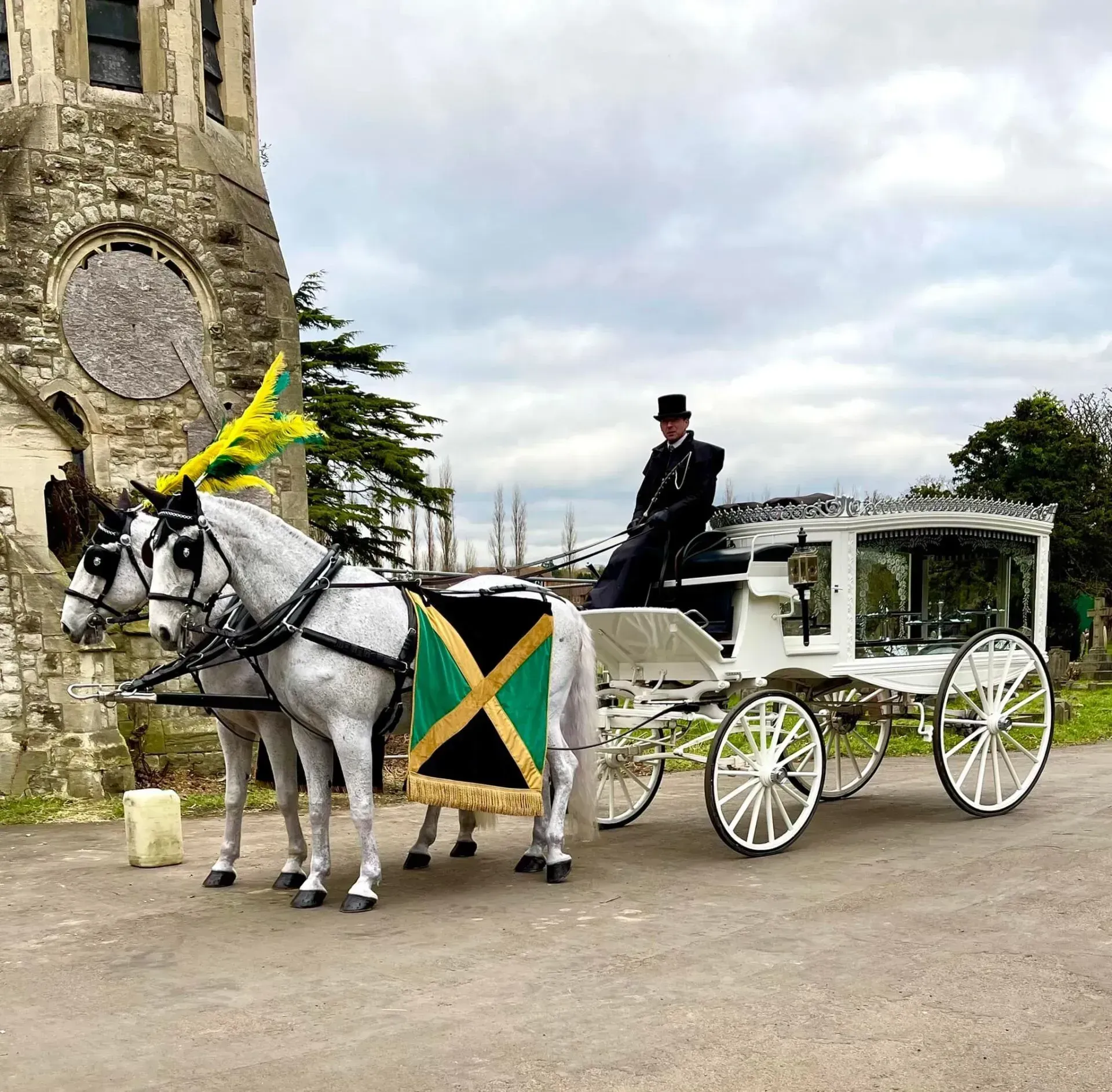 A man is riding a horse drawn carriage in front of a church