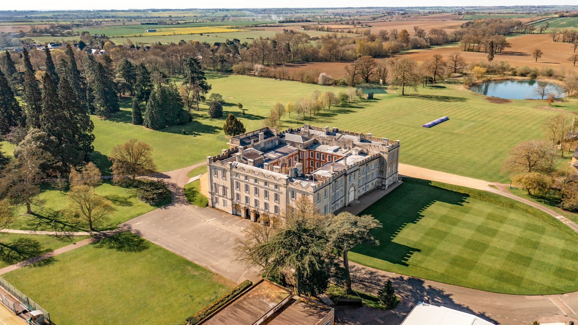 An aerial view of a large castle surrounded by grass and trees