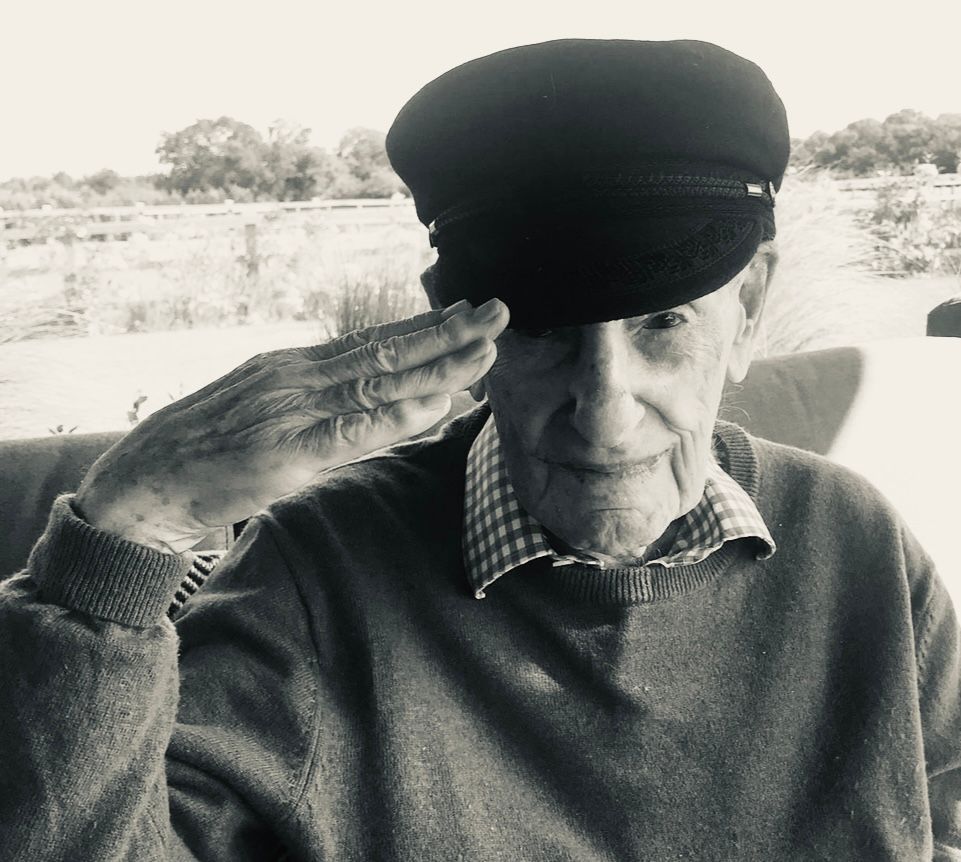 A black and white photo of an elderly man wearing a hat