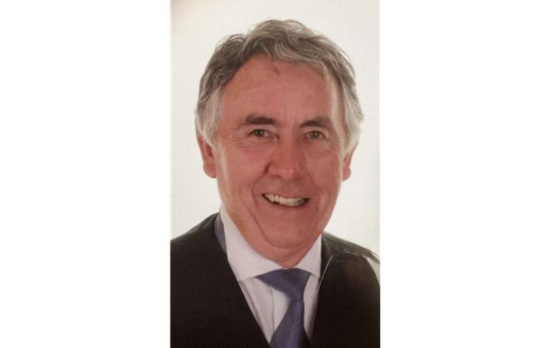 Man in suit smiling at camera.