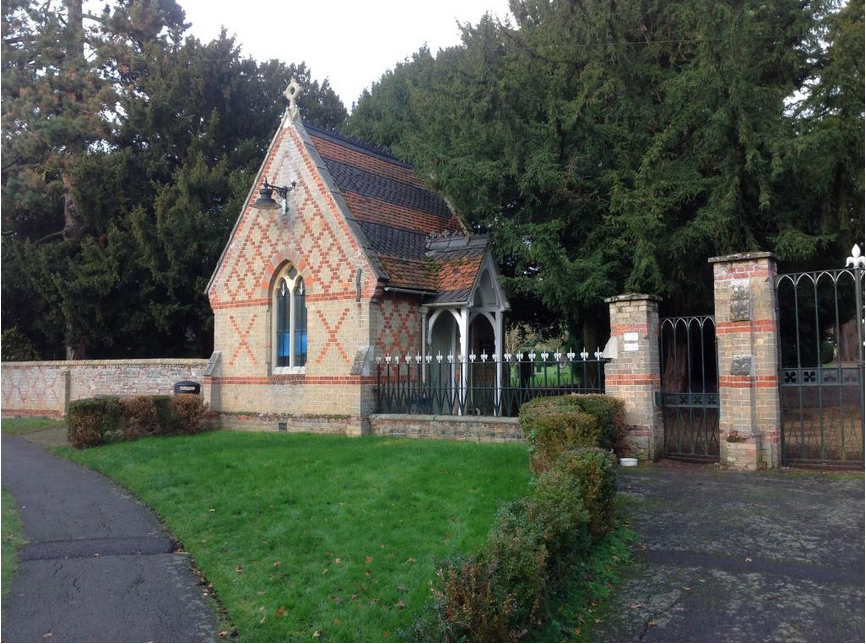 A small brick building with a fence around it