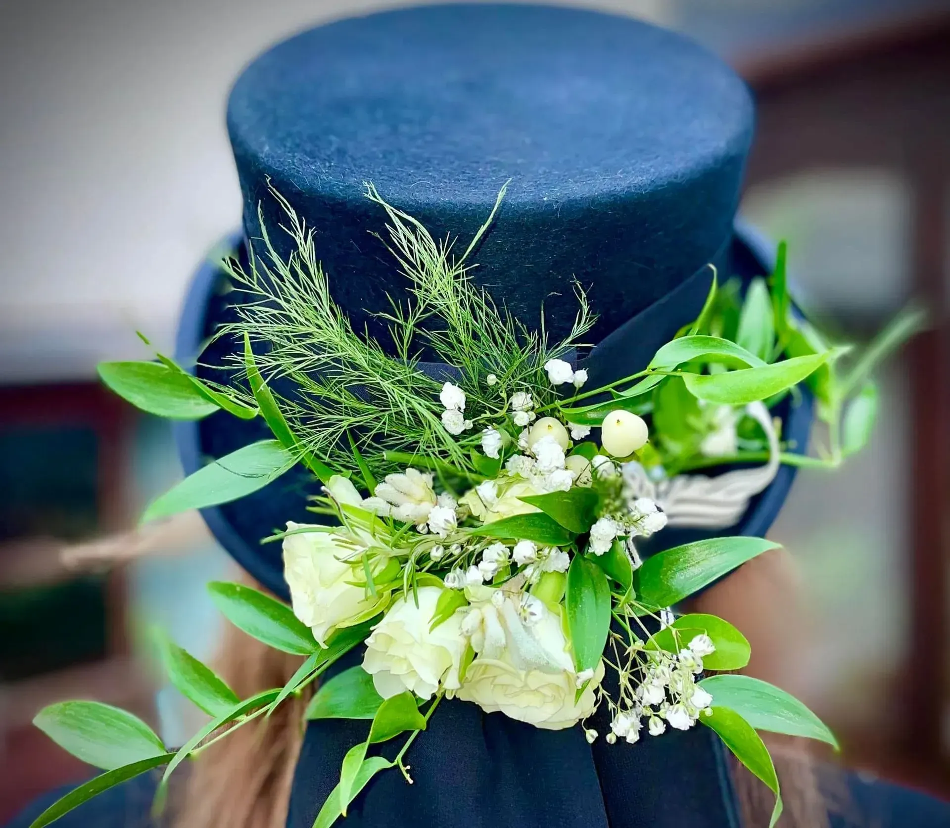 A woman wearing a top hat with flowers on it