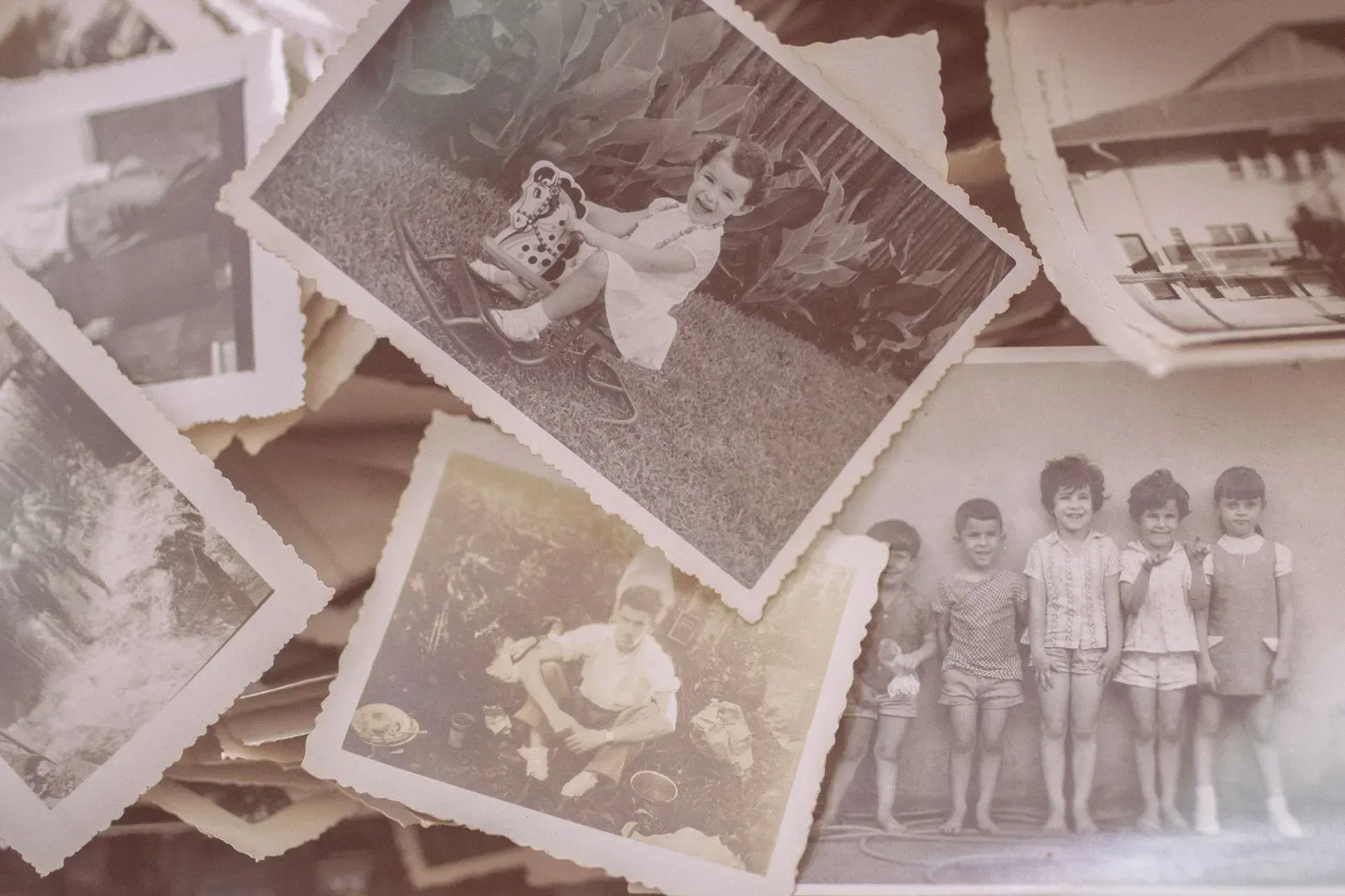 A pile of old photographs including a group of children