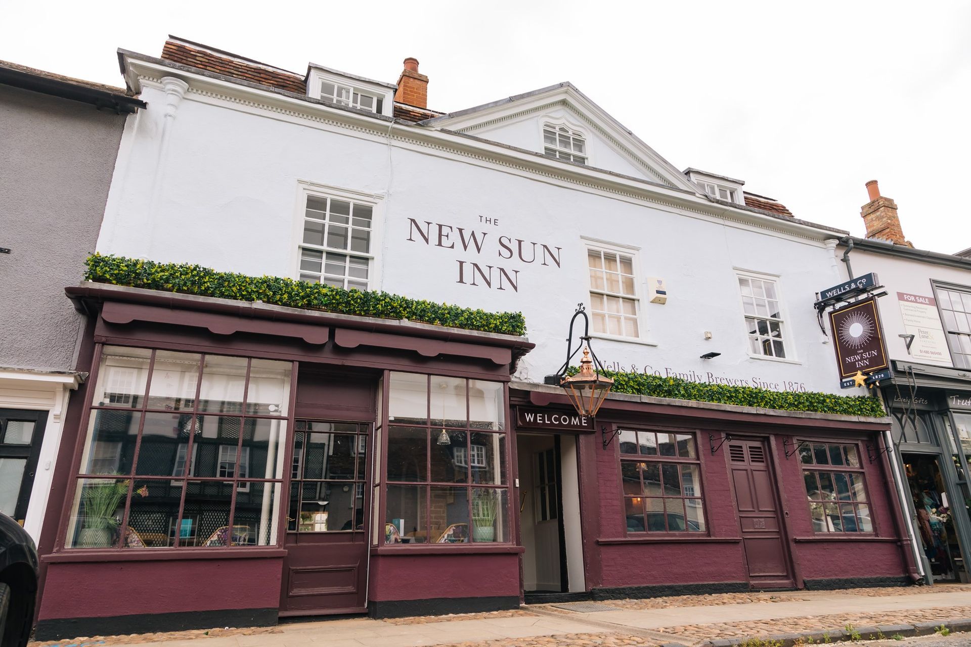 A white building with the word new sun inn on it