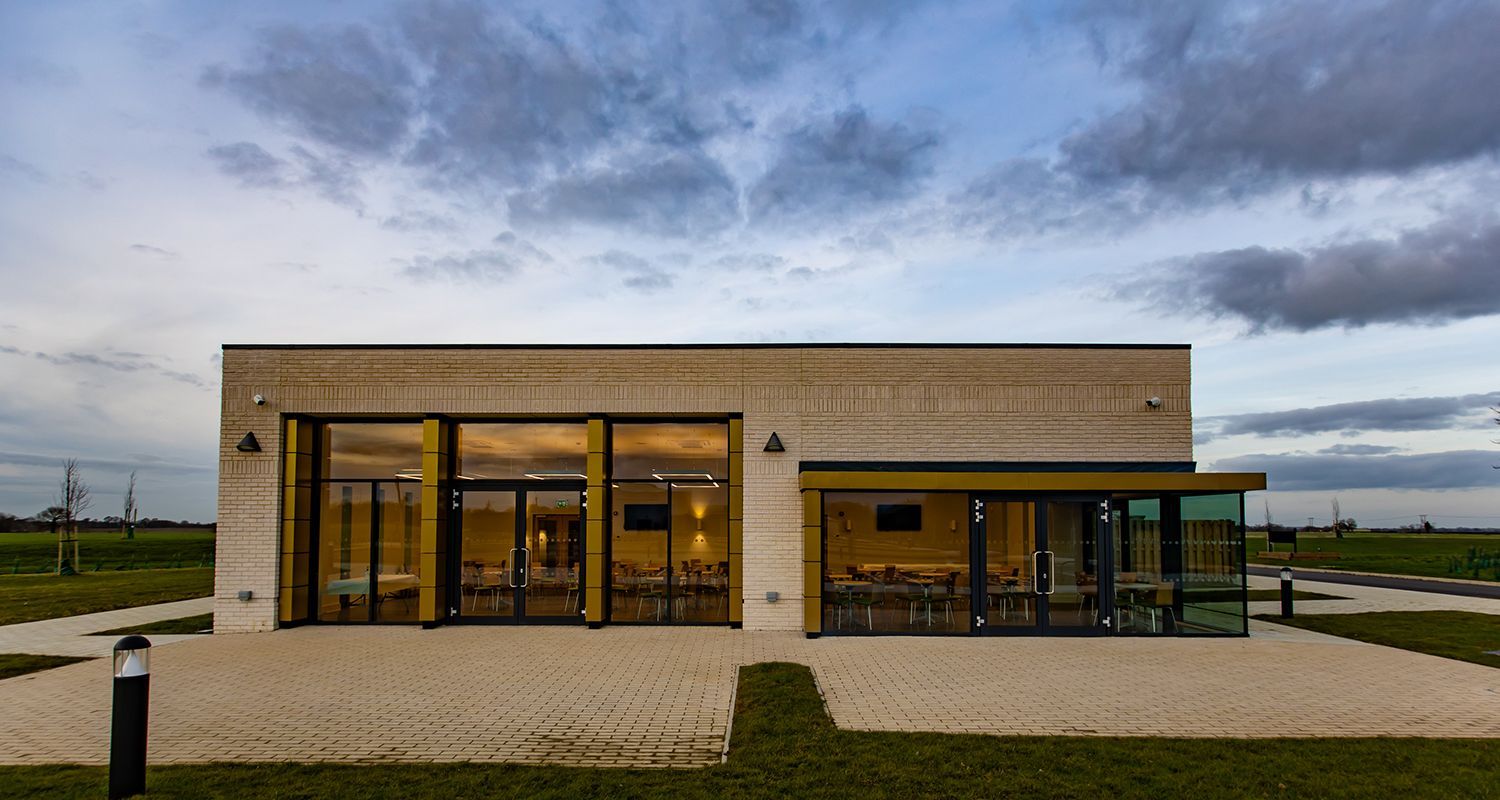 A building with a lot of windows and a cloudy sky in the background