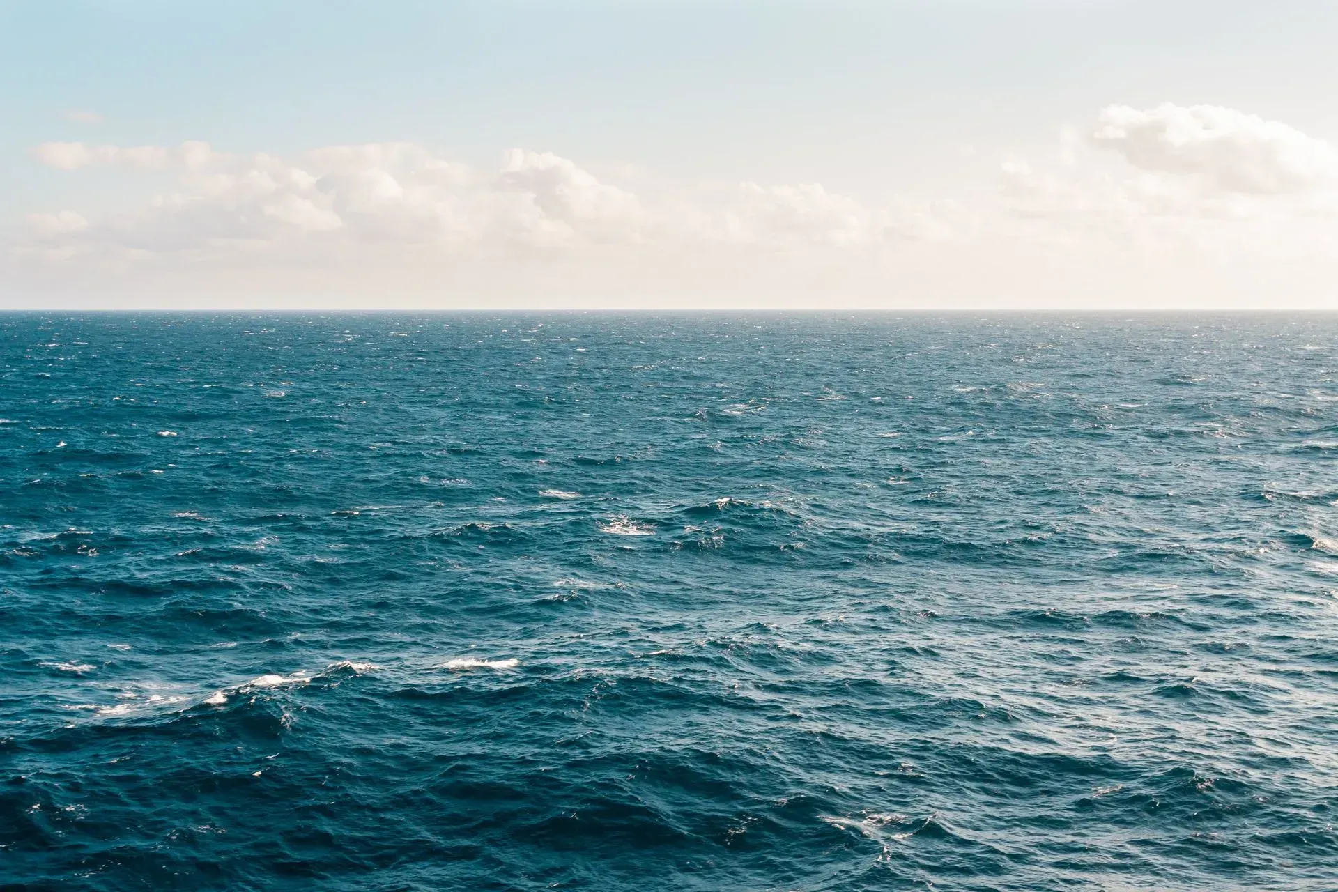 A large body of water with a blue sky in the background