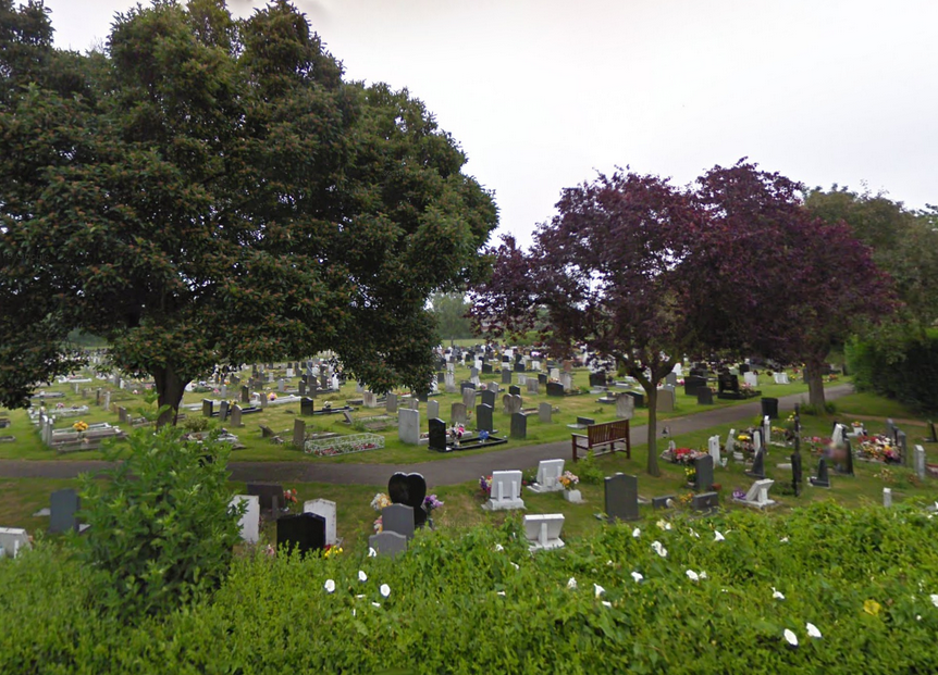 A cemetery with lots of graves and trees