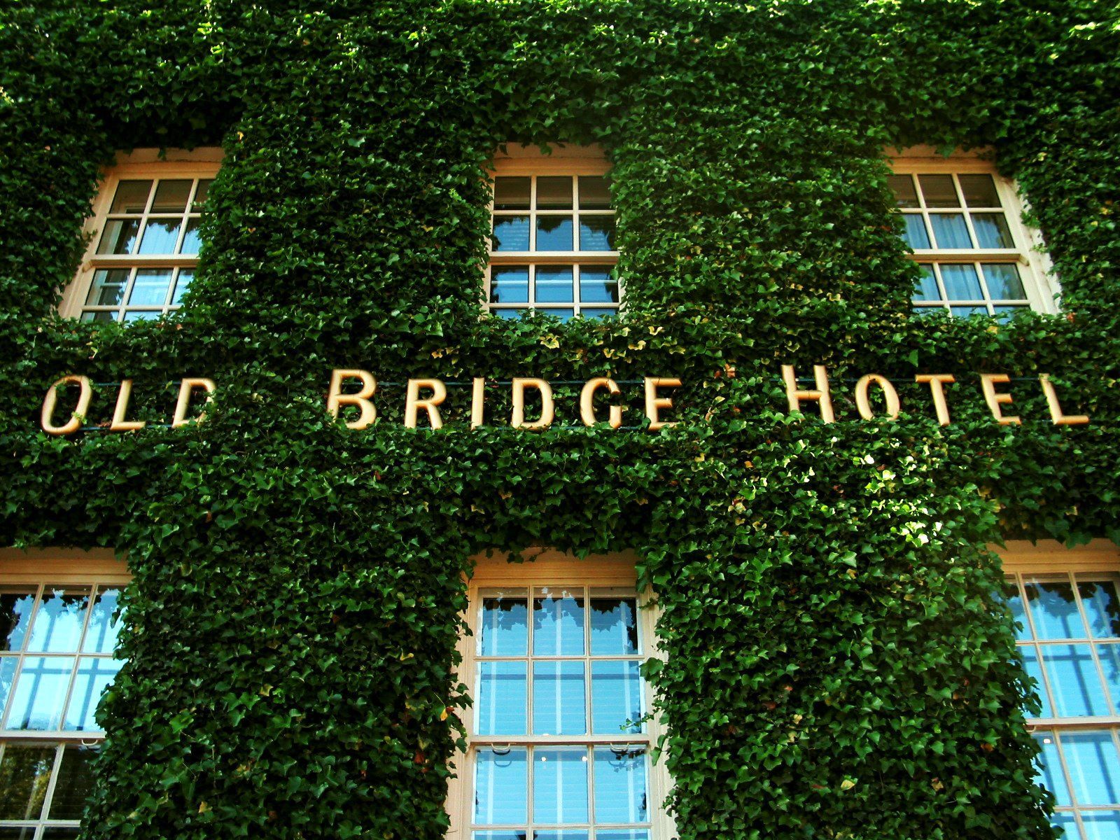 The old bridge hotel is covered in green ivy