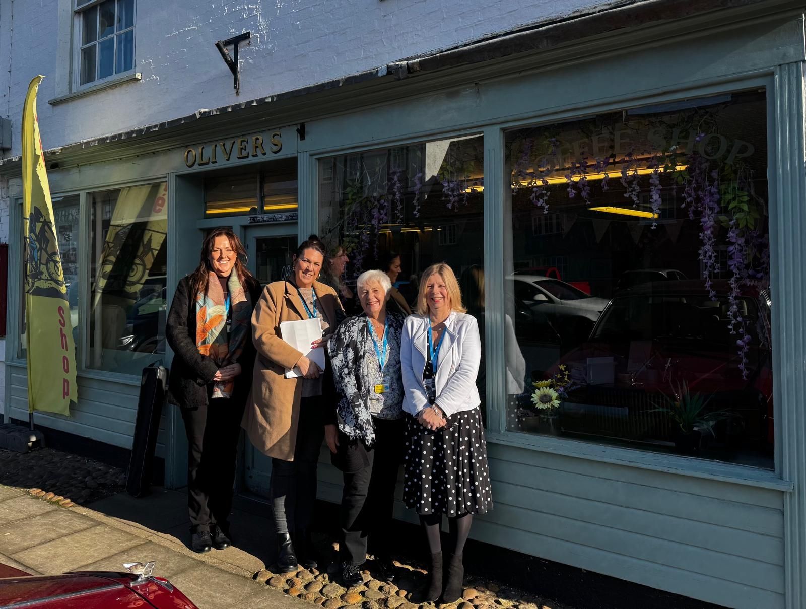 A group of women standing in front of a store