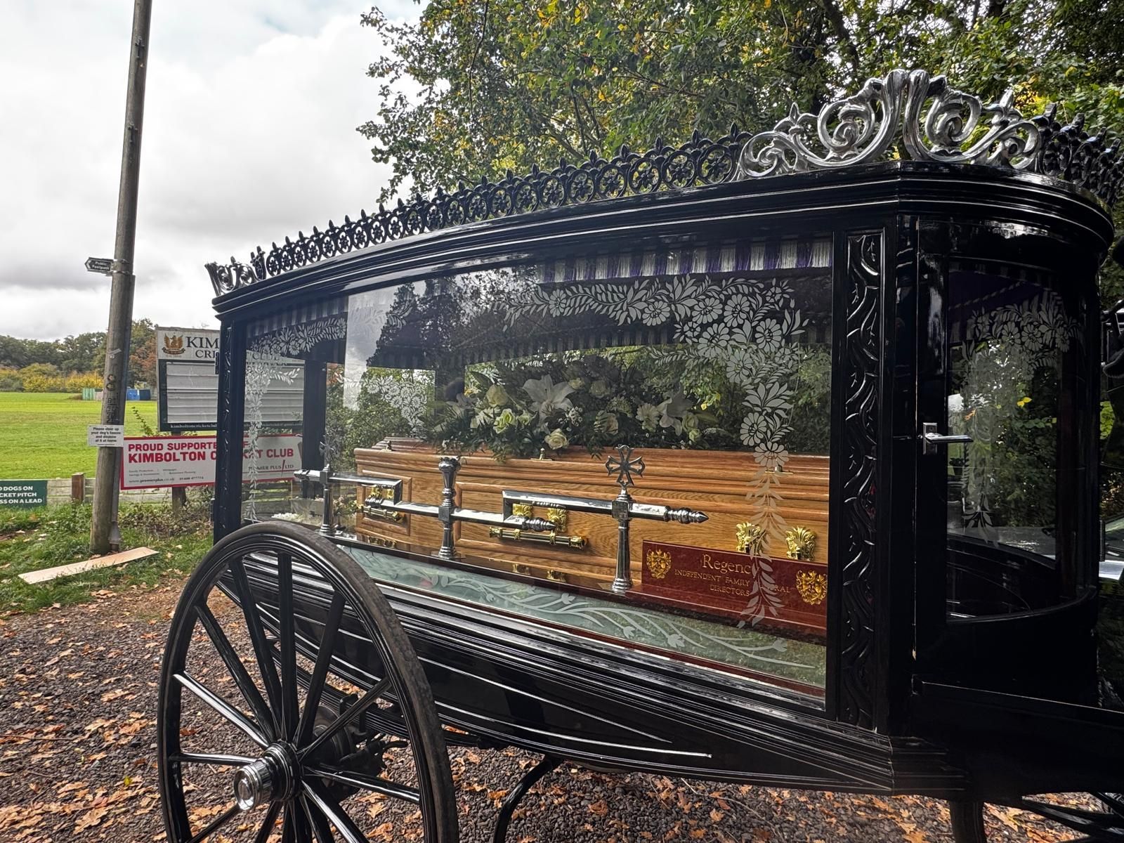 Three black cars are parked in a driveway in front of a building.
