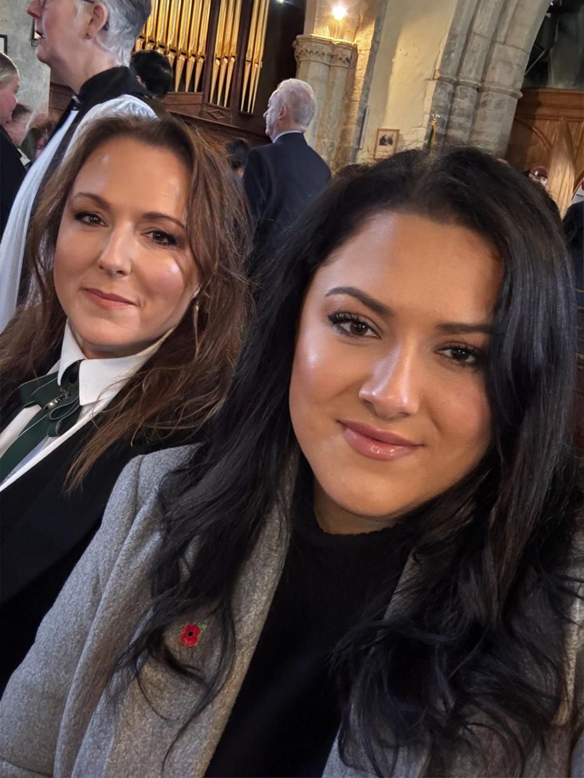 A group of people standing on a red carpet in front of a building