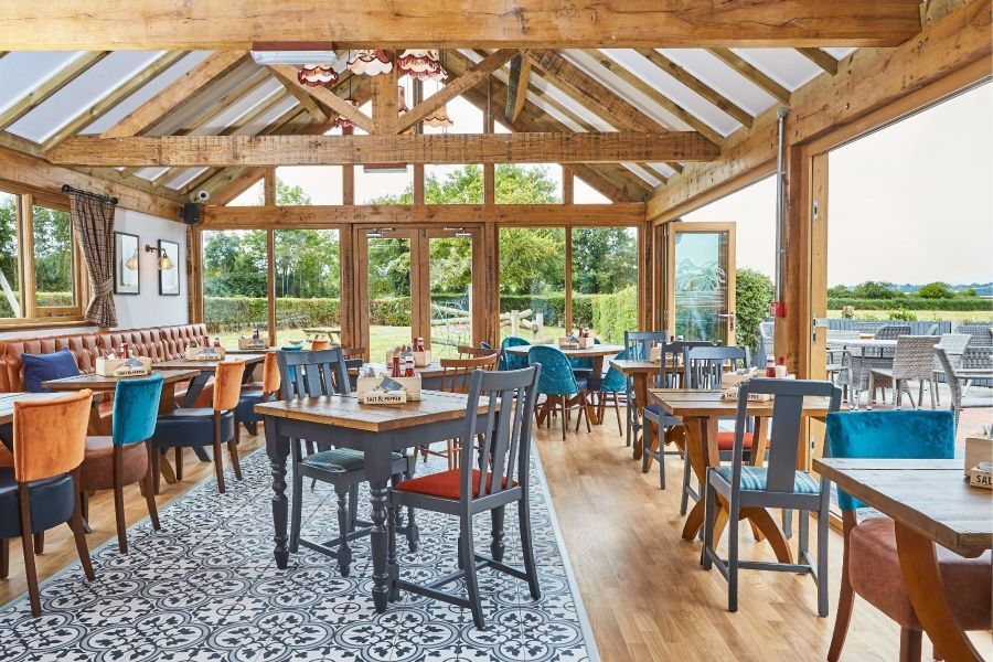 A restaurant with tables and chairs and a large window