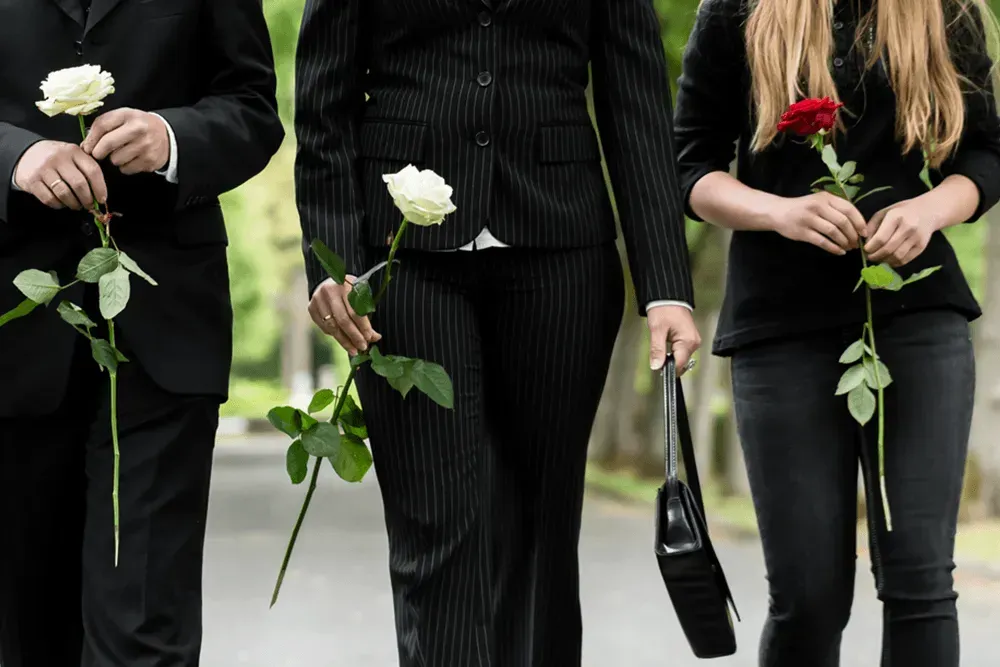 A group of people walking down a street holding flowers