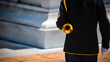 A man in a black uniform is holding a trumpet