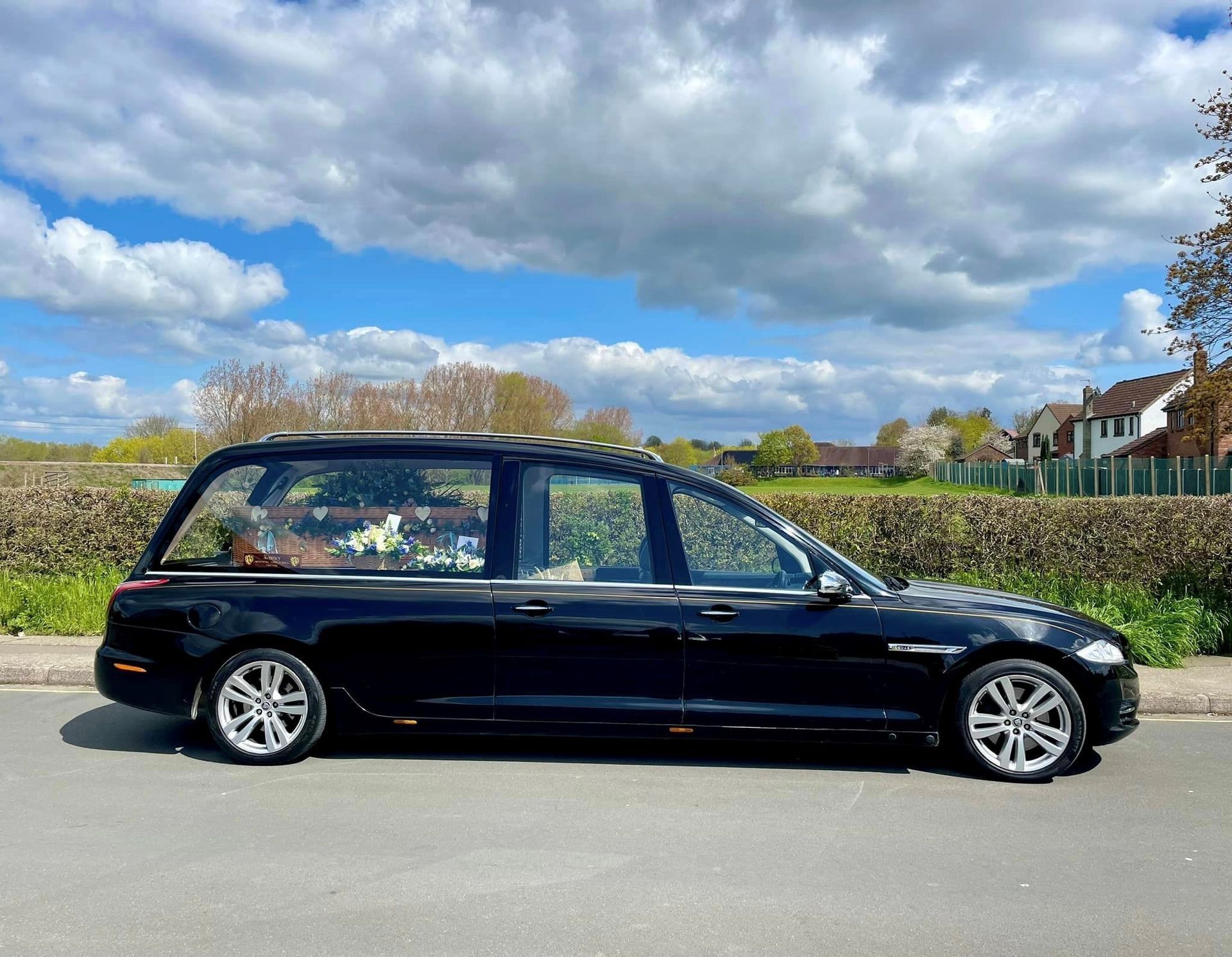 A black car is parked on the side of the road.