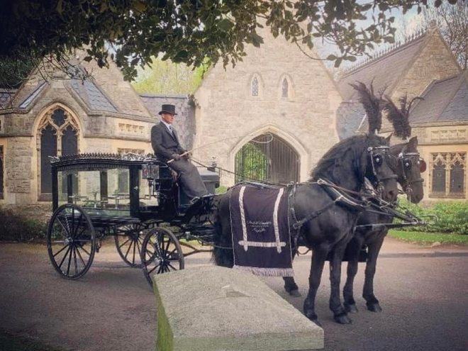 A horse drawn carriage is parked in front of a church