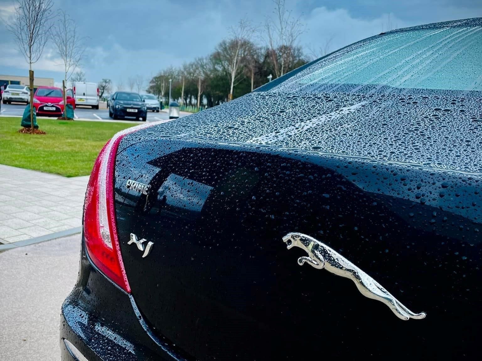 A black jaguar car is parked in a parking lot