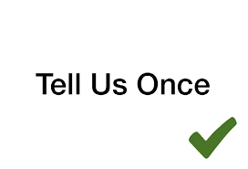 A sign that says tell us once with a green check mark