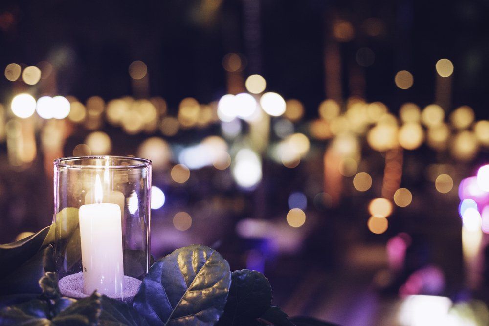 A lit candle in a glass with a blurry background