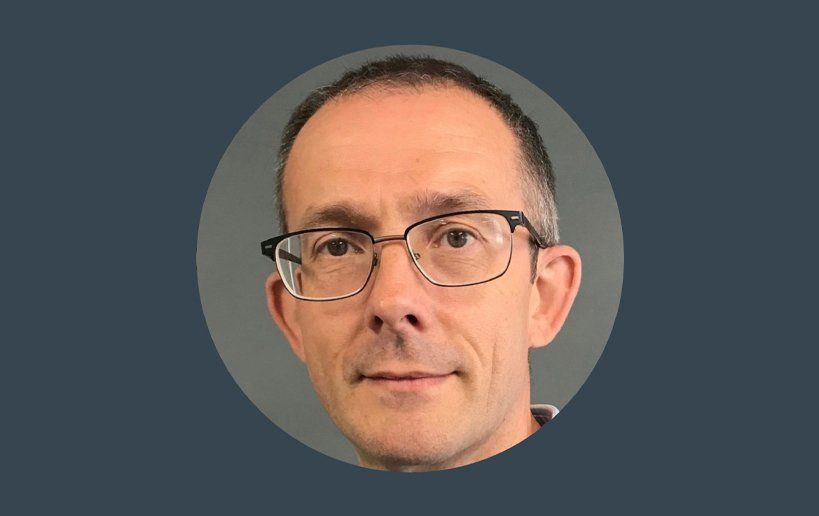 A man wearing glasses is in a circle on a blue background.