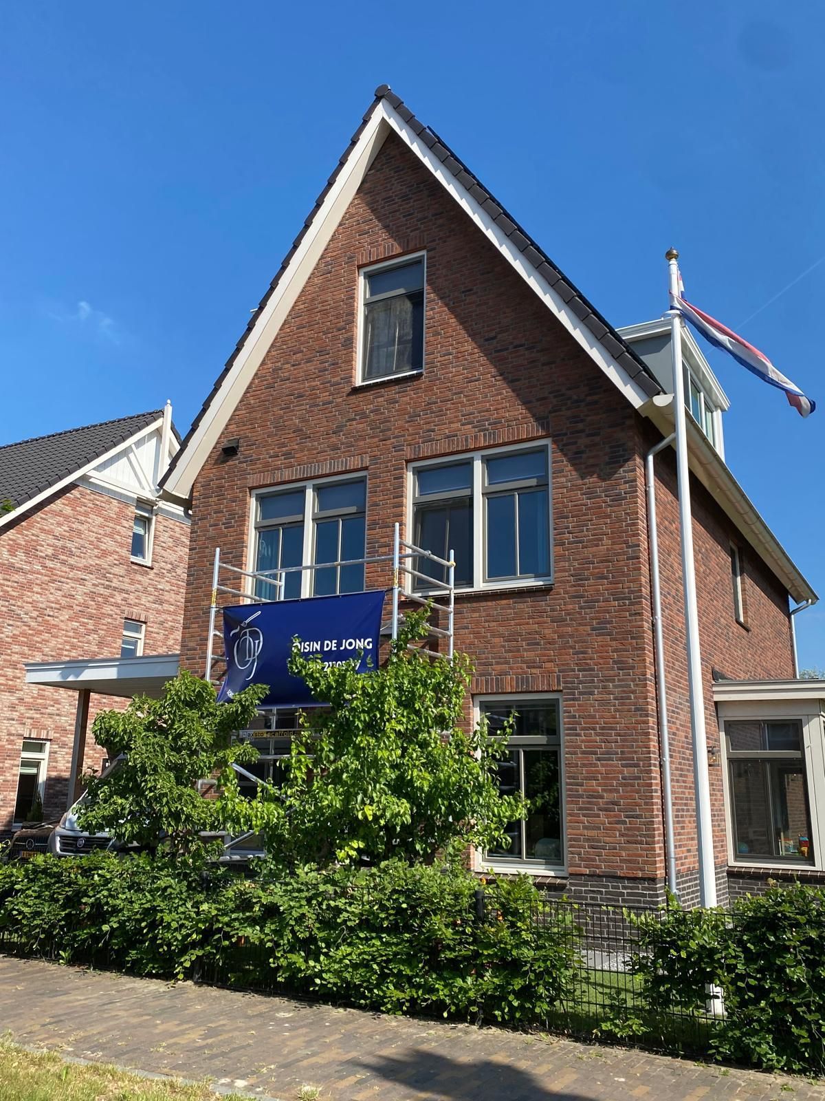 Een groot bakstenen huis met een vlag ervoor.