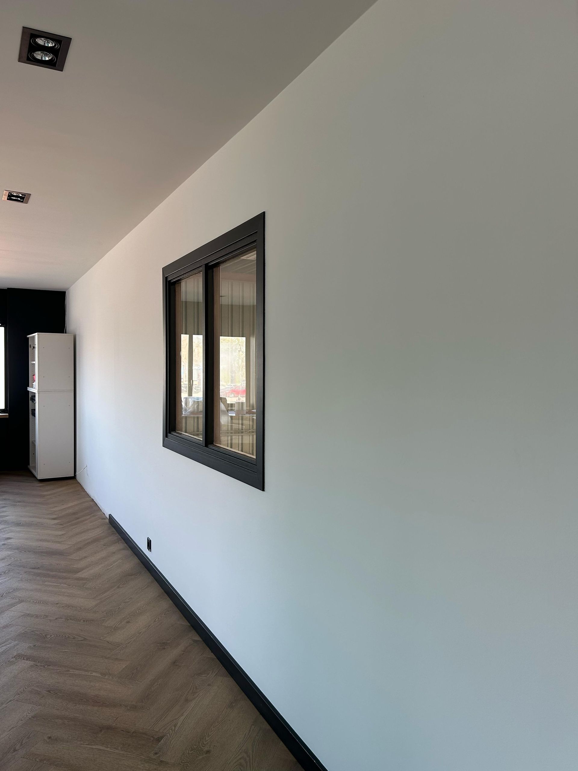 Een lange gang met twee ramen in de muur