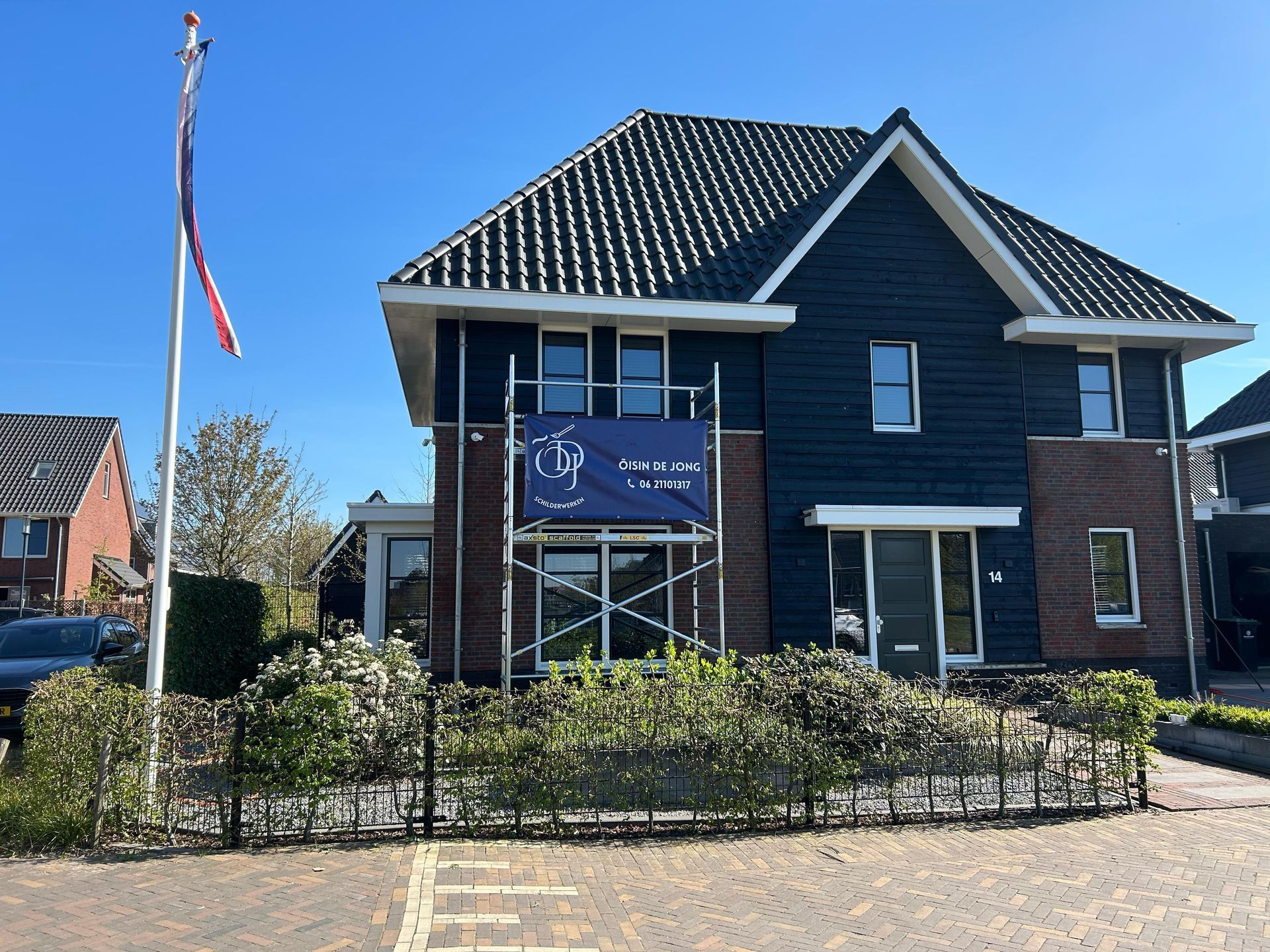Een blauw huis met een vlag ervoor
