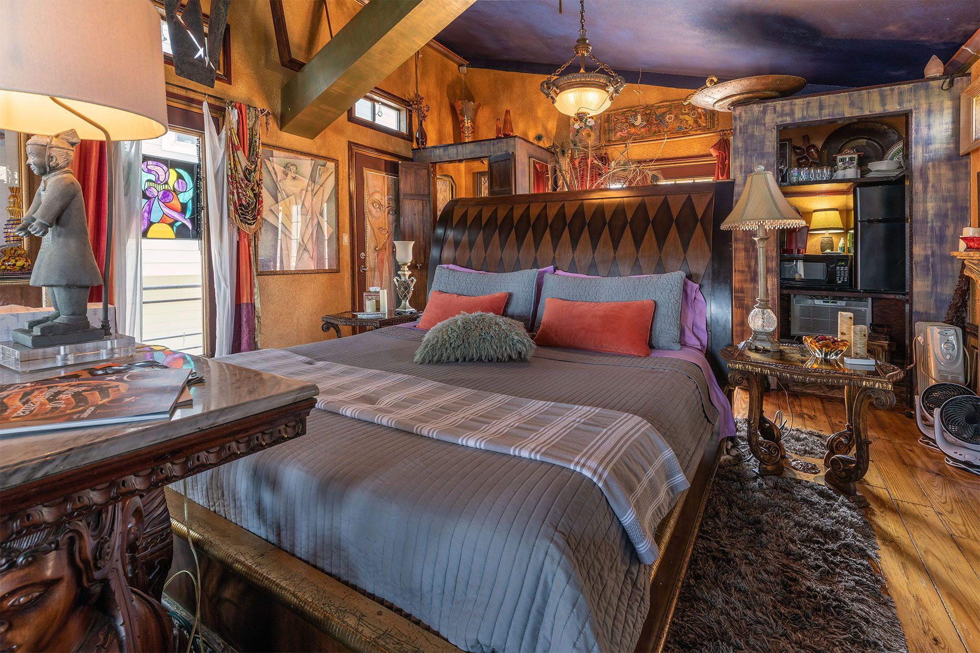 Eclectic bedroom with ornate furnishings; a large bed is the focal point.