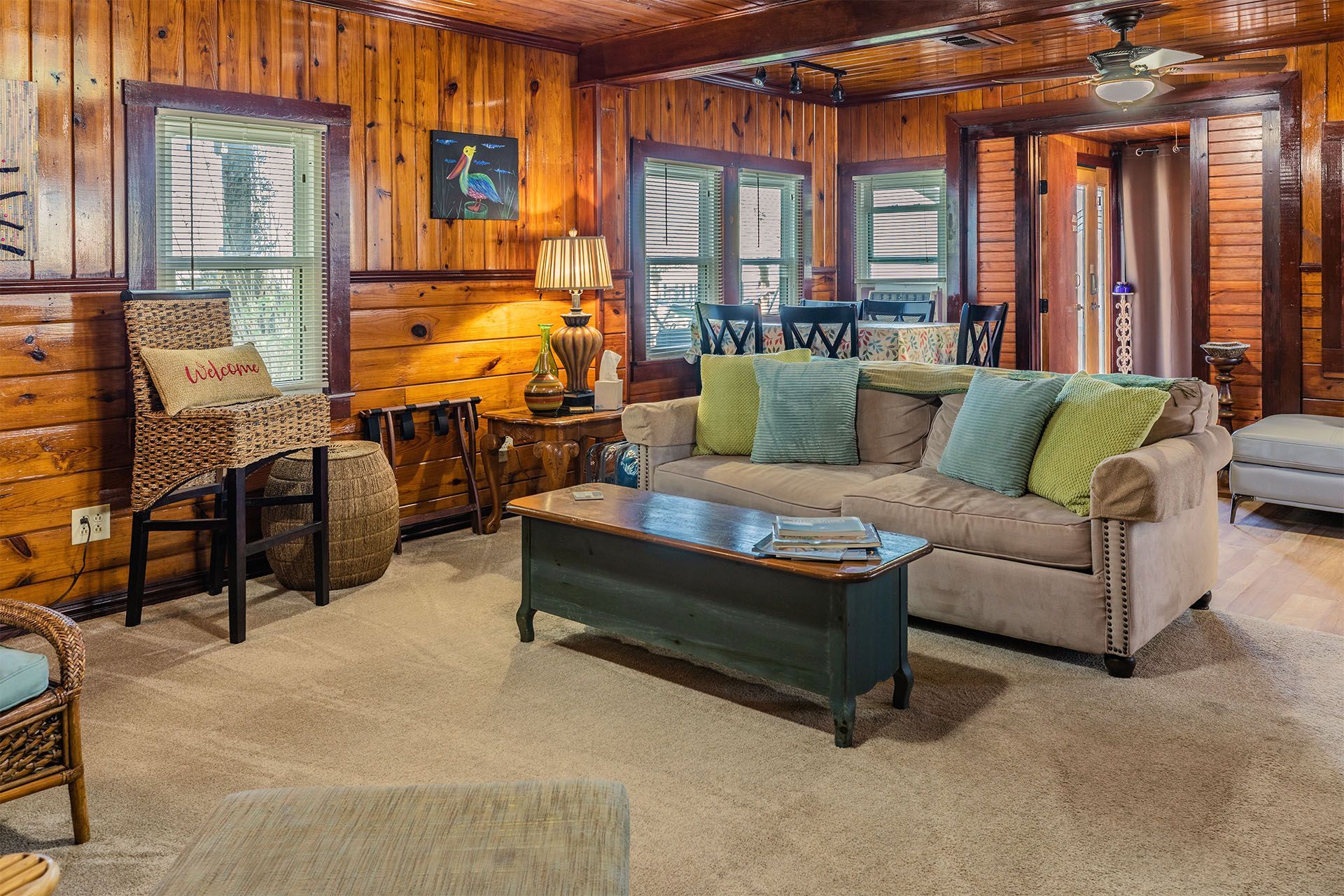 Cozy living room with wood paneling, beige couch, and coffee table.