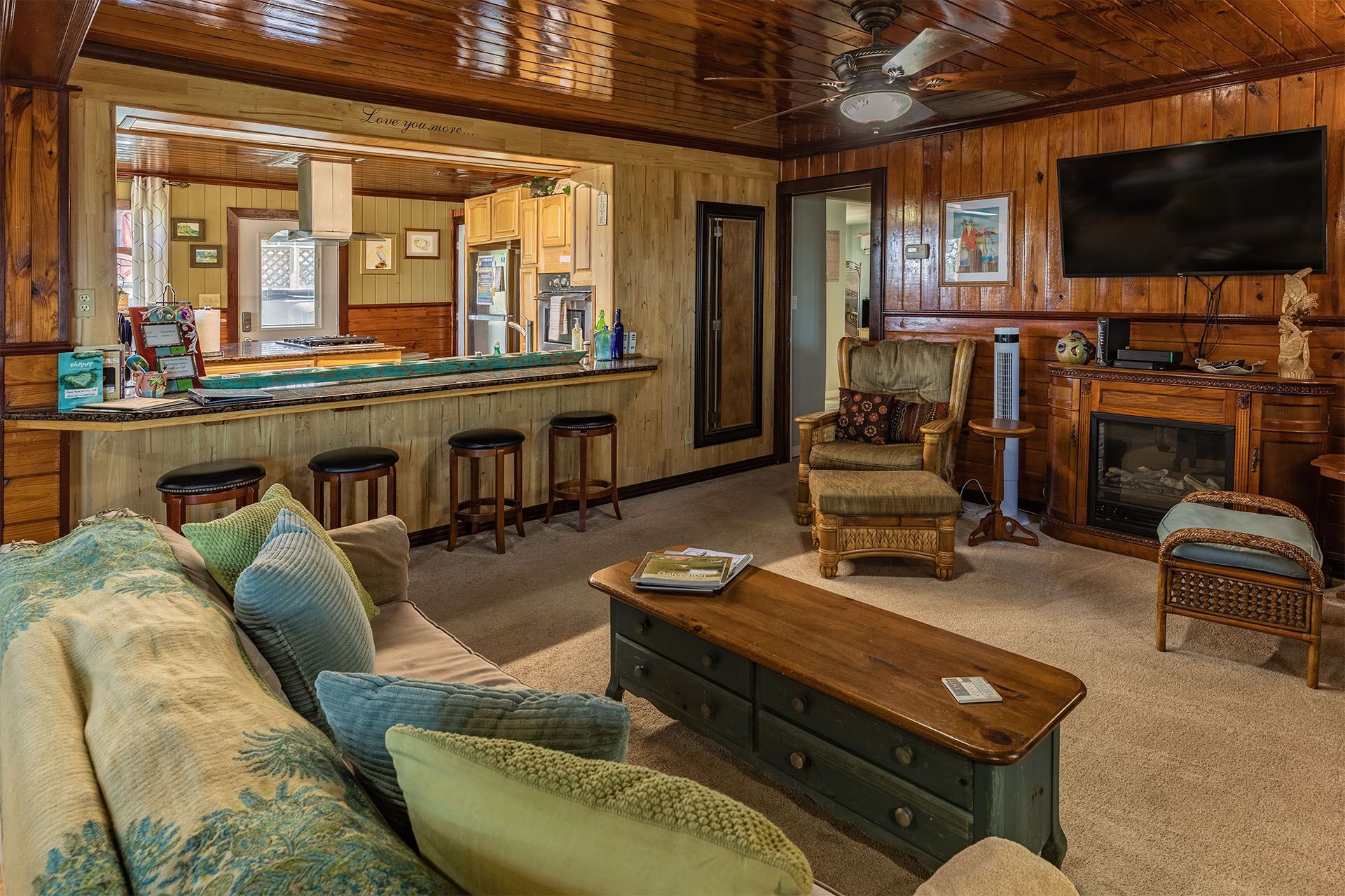 Living room with a bar, fireplace, TV, and light green couch.