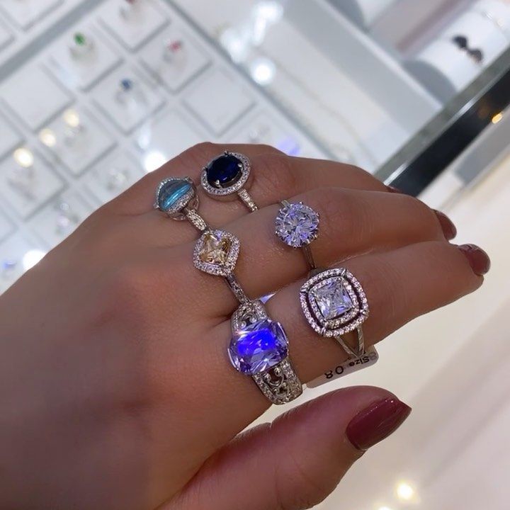 A woman 's hand with a bunch of rings on it