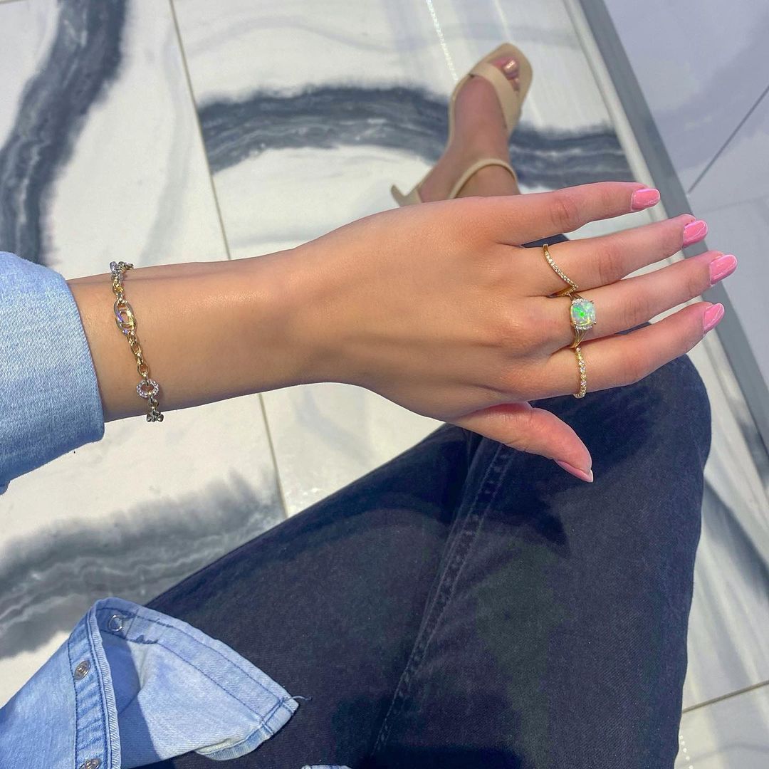 A woman wearing a bracelet and a ring on her left hand