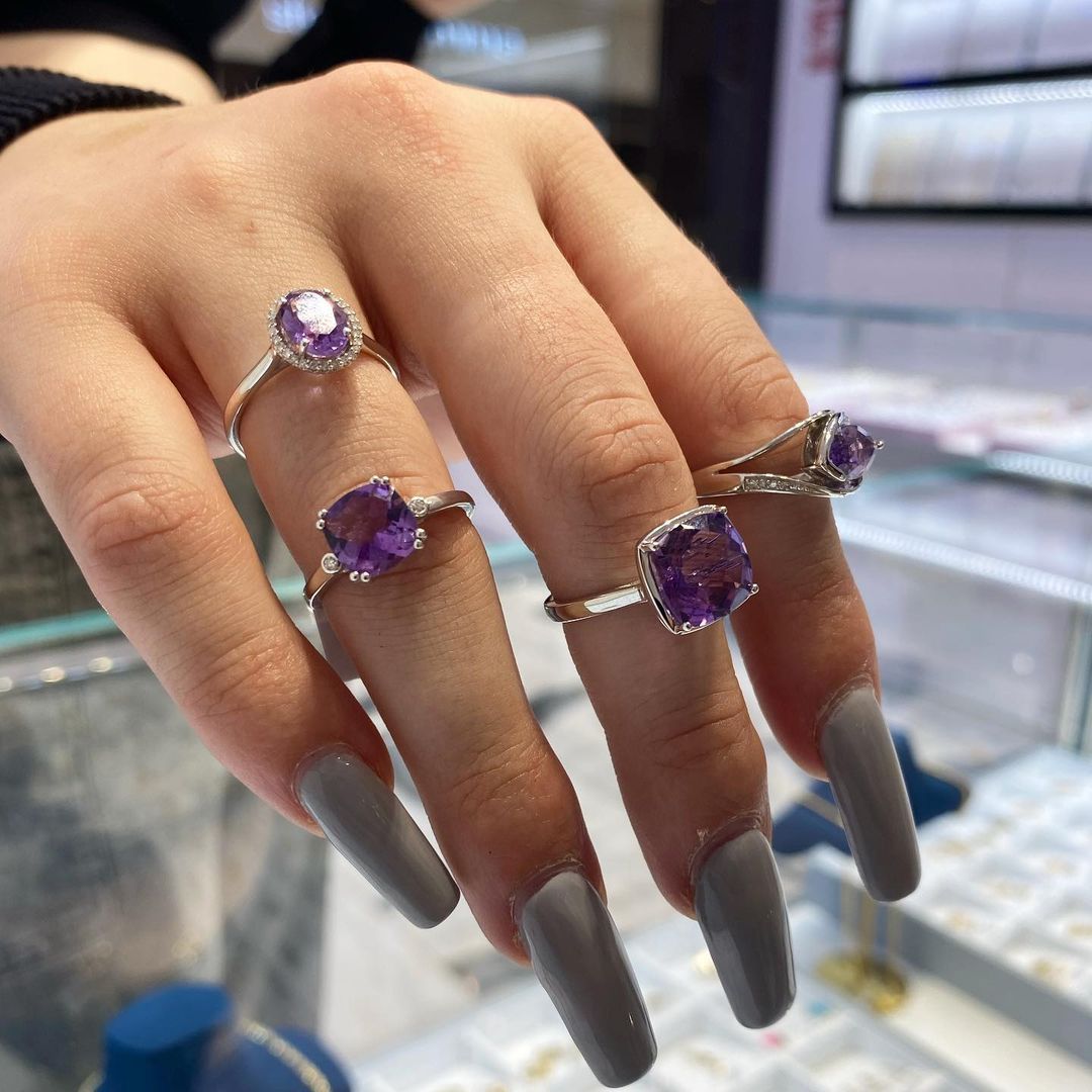 A woman 's hand with a lot of rings on it