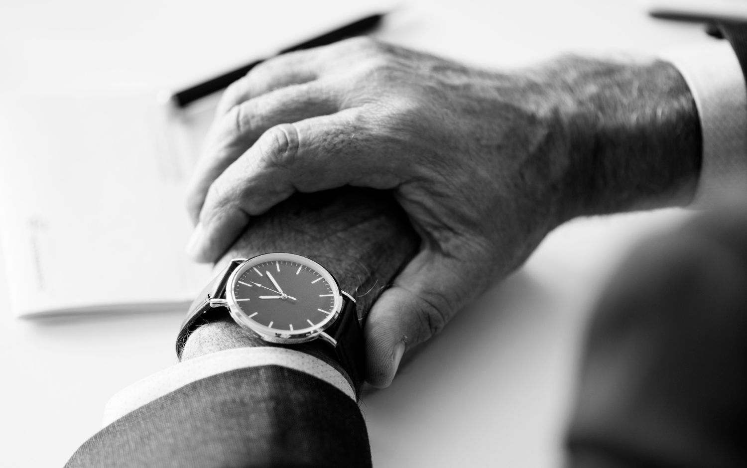 A man in a suit is looking at his watch.