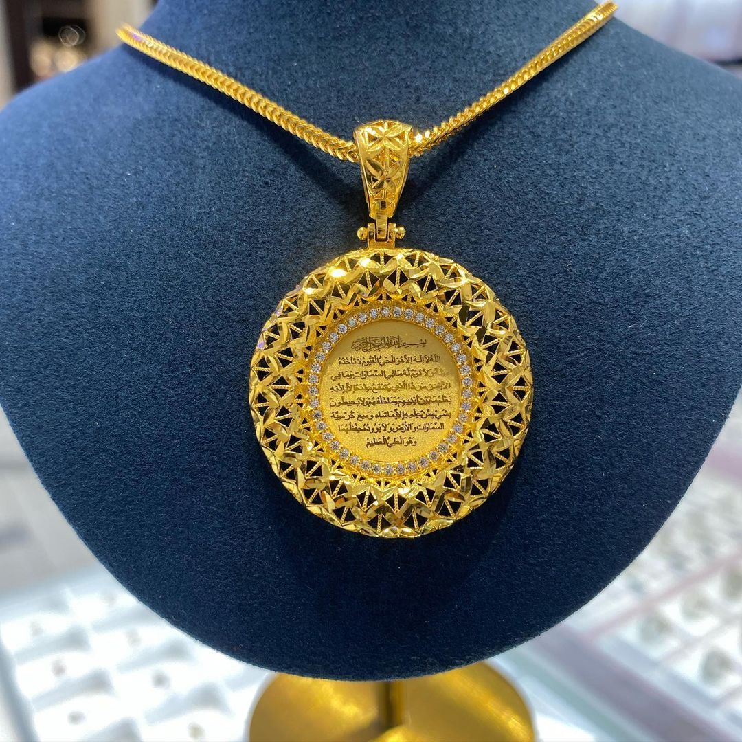 A gold necklace with arabic writing on it