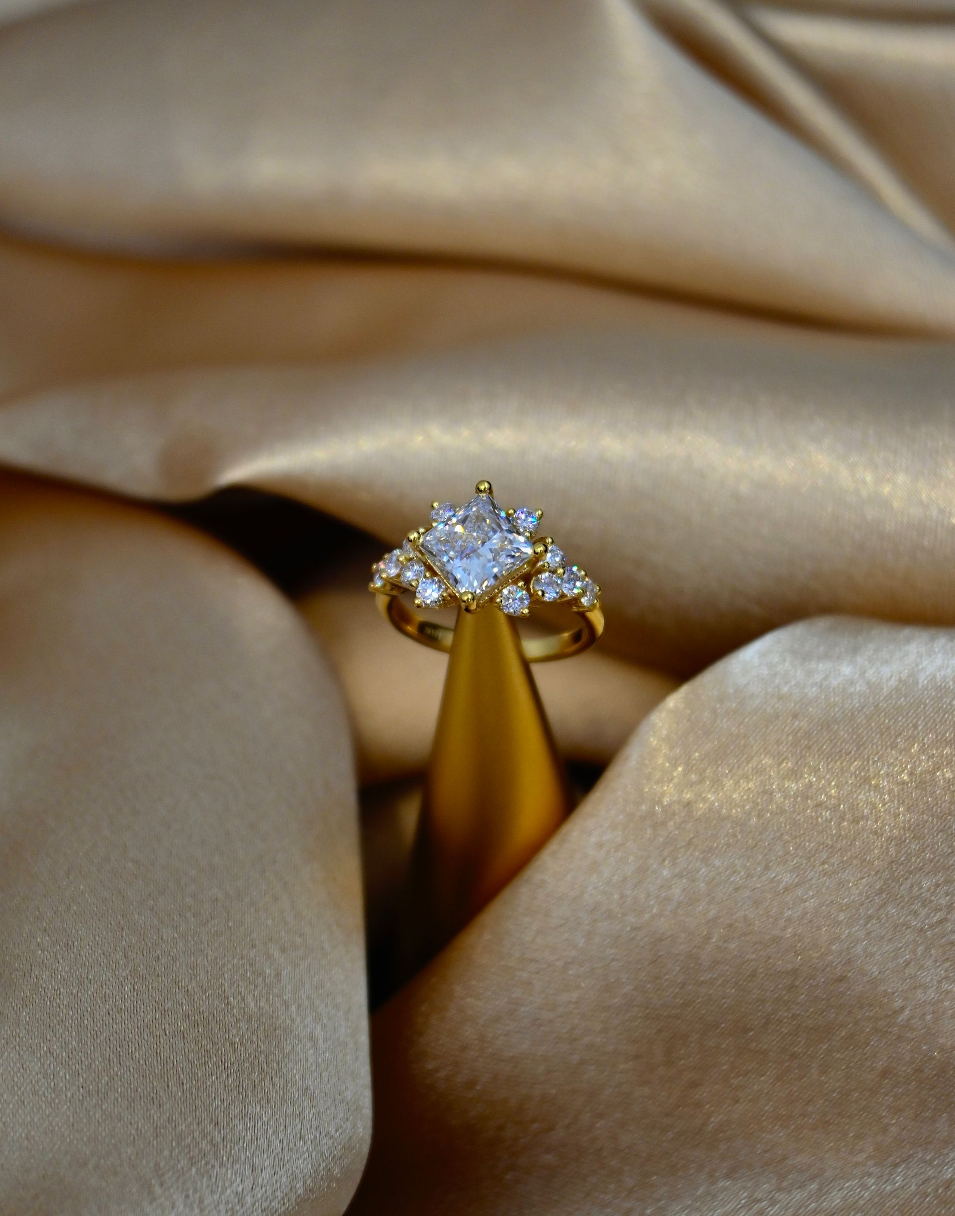 A gold ring is sitting on top of a gold cloth.