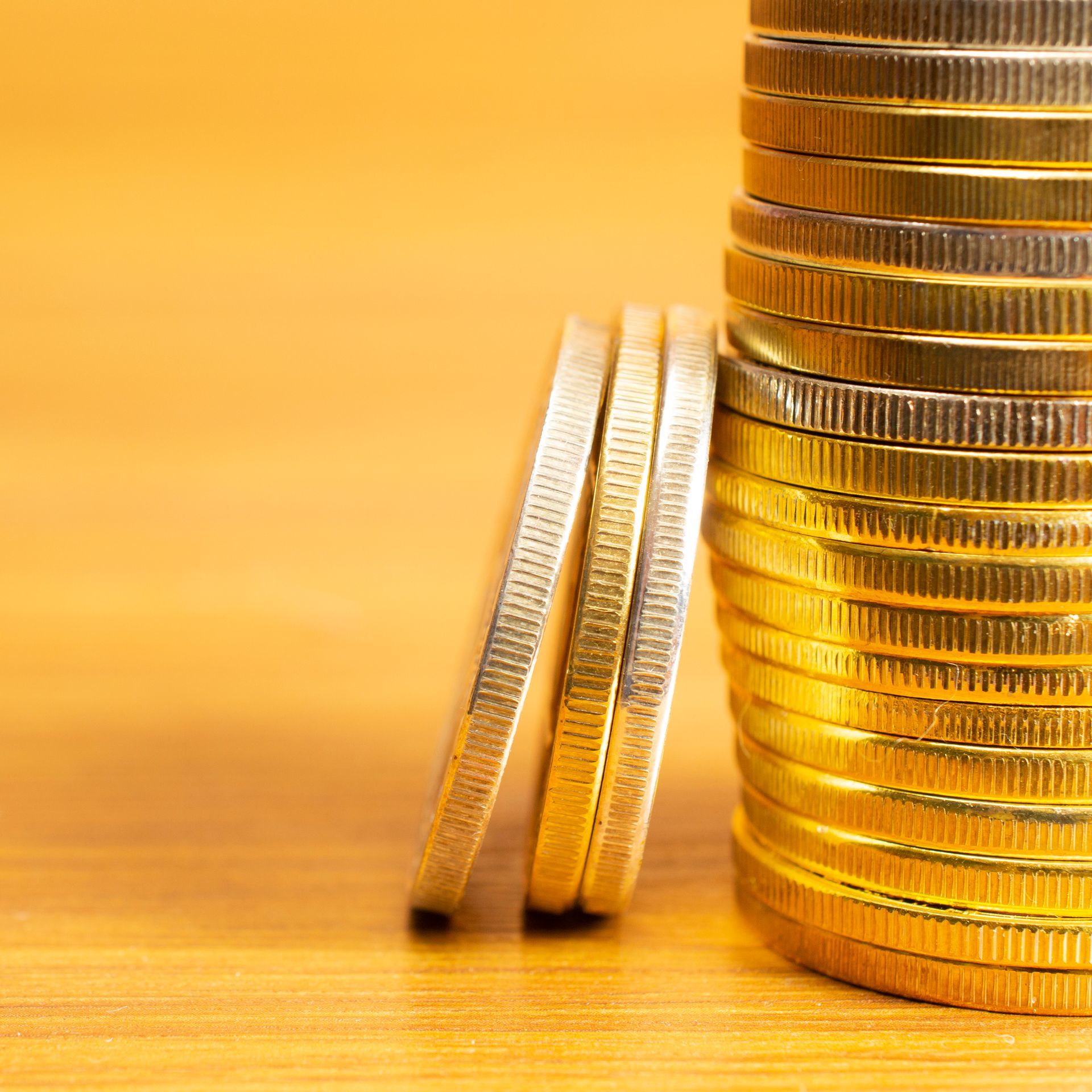 A stack of gold coins on a wooden table