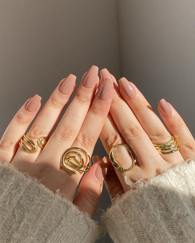 A woman is wearing a lot of rings on her fingers.