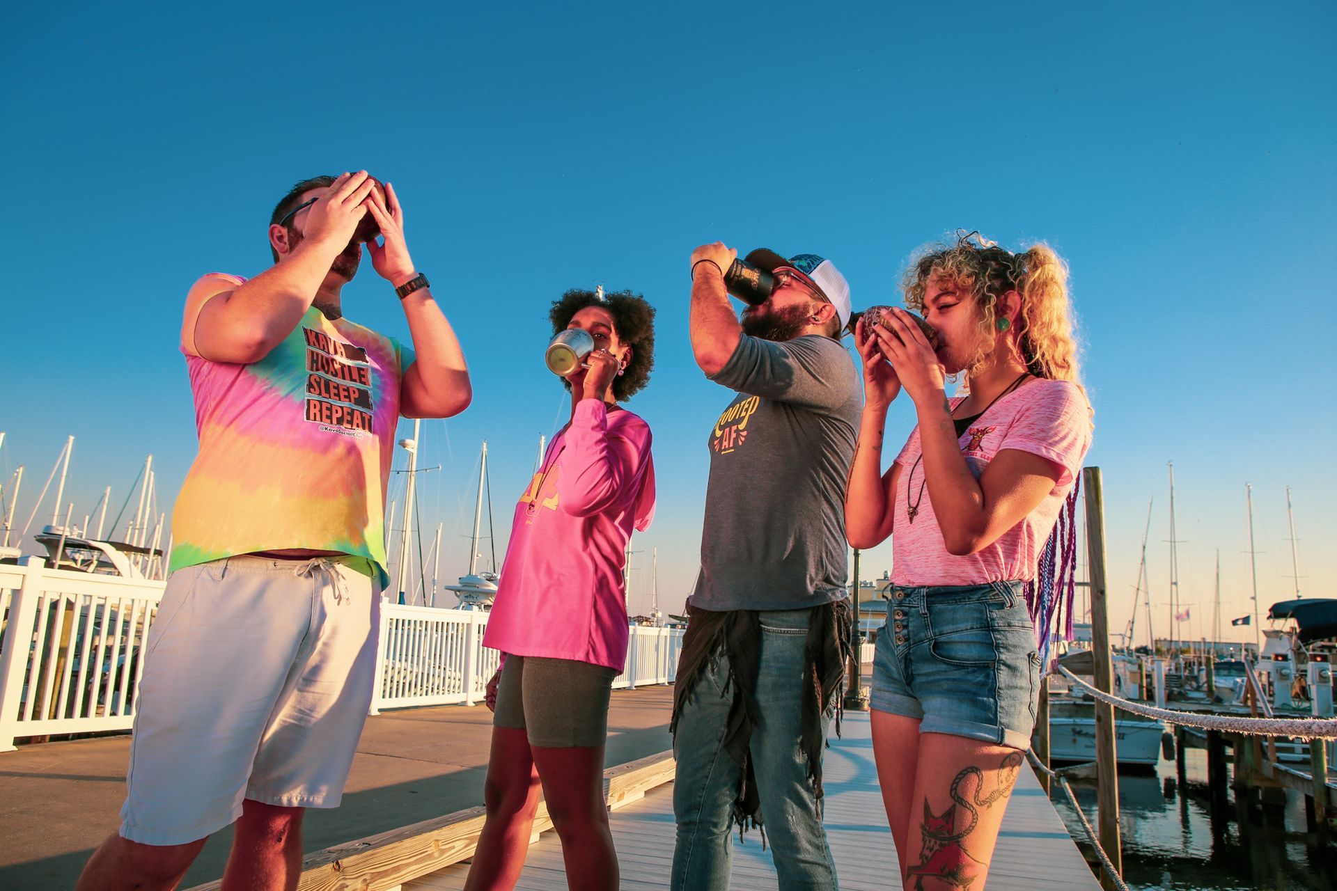 A group of people are standing on a dock drinking kave