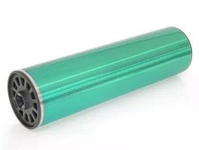 Um cilindro verde com borda preta sobre uma superfície branca.