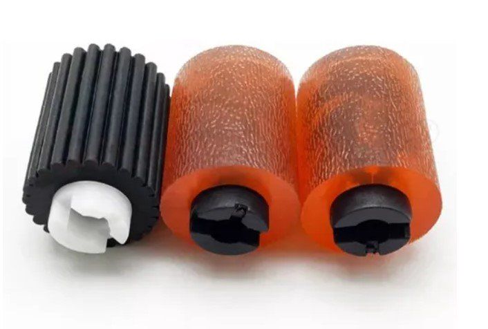 Três rolos de borracha estão colocados um ao lado do outro em uma superfície branca.