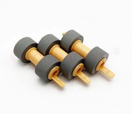 Três rolos de papel estão um em cima do outro sobre uma superfície branca.