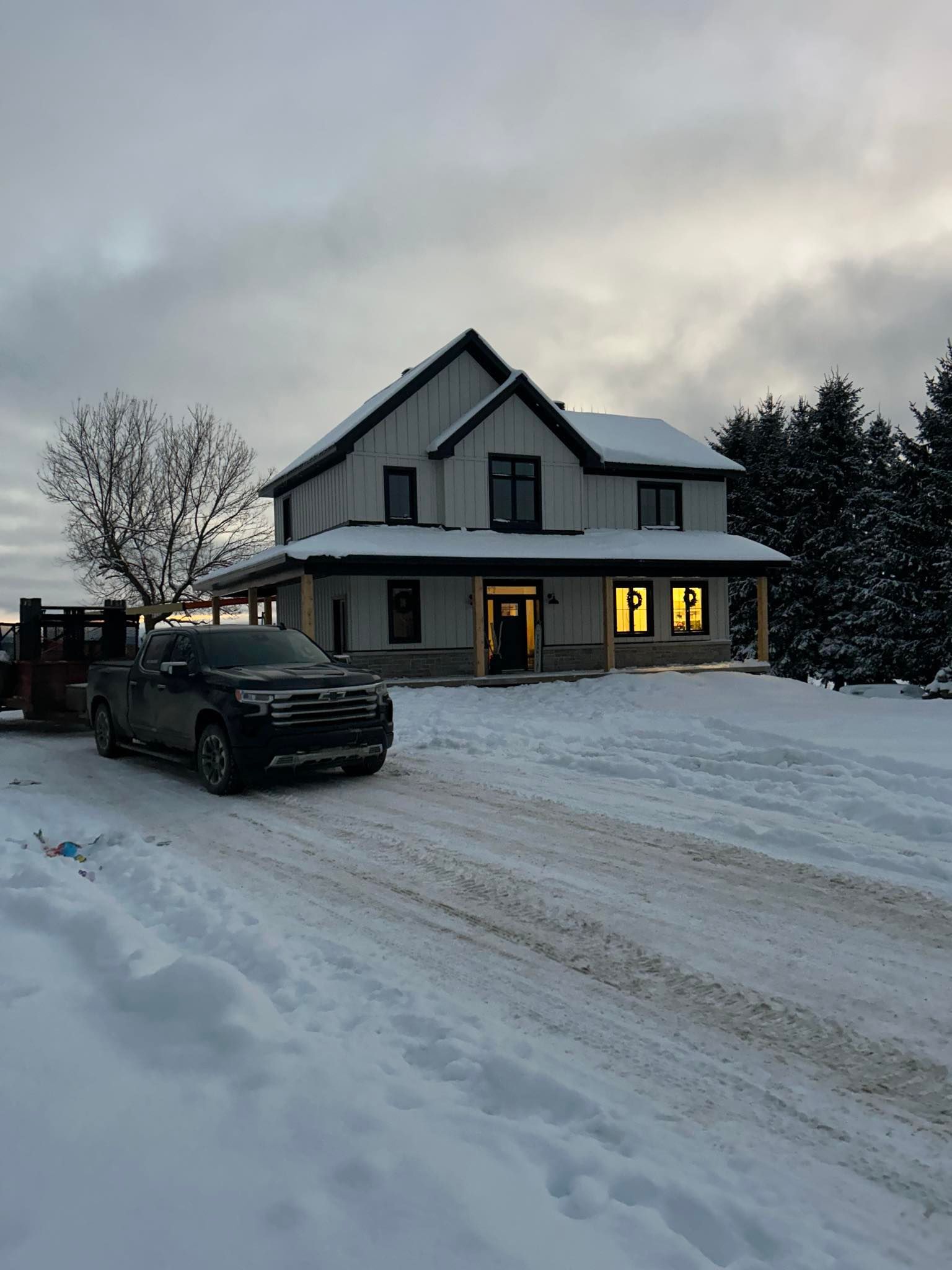 Un camion est garé devant une maison sous la neige.