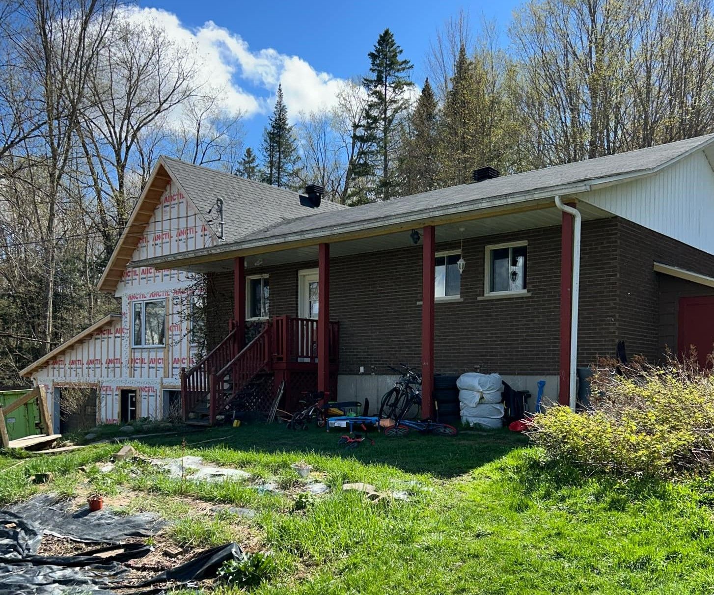 Une maison est en construction au milieu d'un champ herbeux.