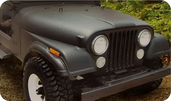 Black off-road Jeep with round headlights and large tires parked outdoors