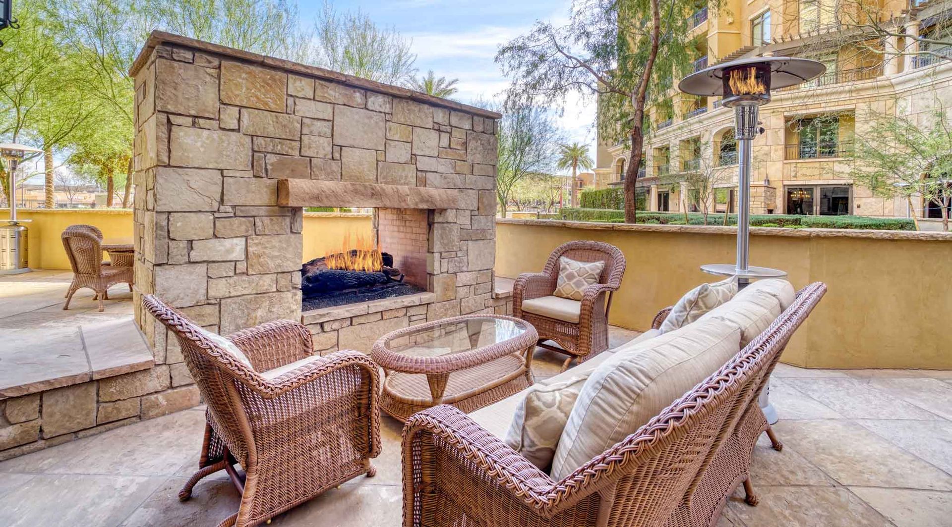 Outdoor stone fireplace with patio seating.