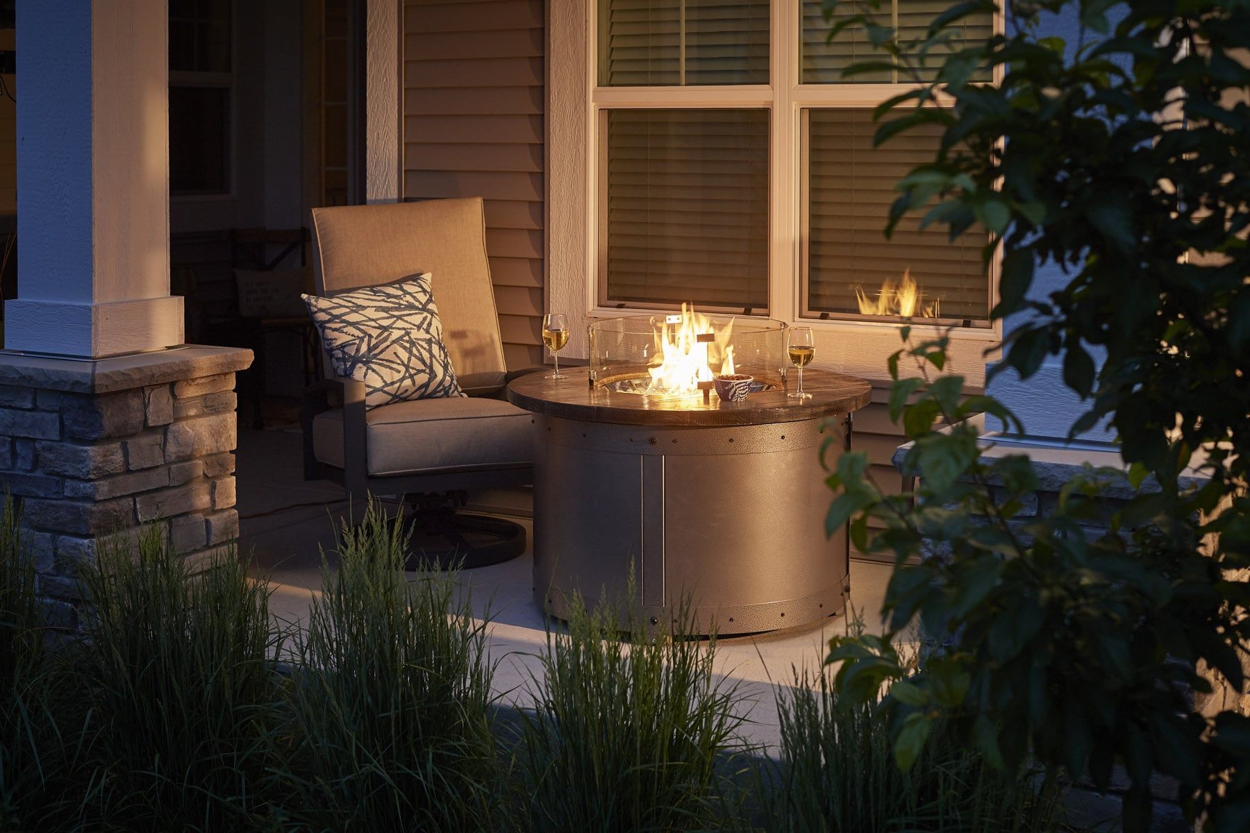 Fire pit on a porch with a chair and drinks, evening setting. Fire pit on a porch with a chair and drinks, evening setting.