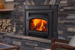 Fireplace with flames, built into a stone wall. Fire tools stand beside it. Fireplace with flames, built into a stone wall. Fire tools stand beside it.