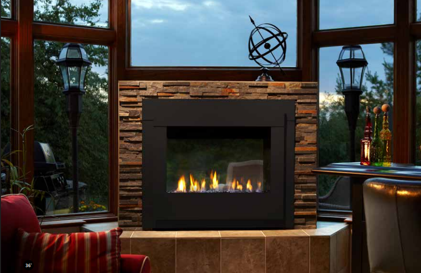 Cozy modern fireplace framed by large windows, with stone surround and warm firelit seating area