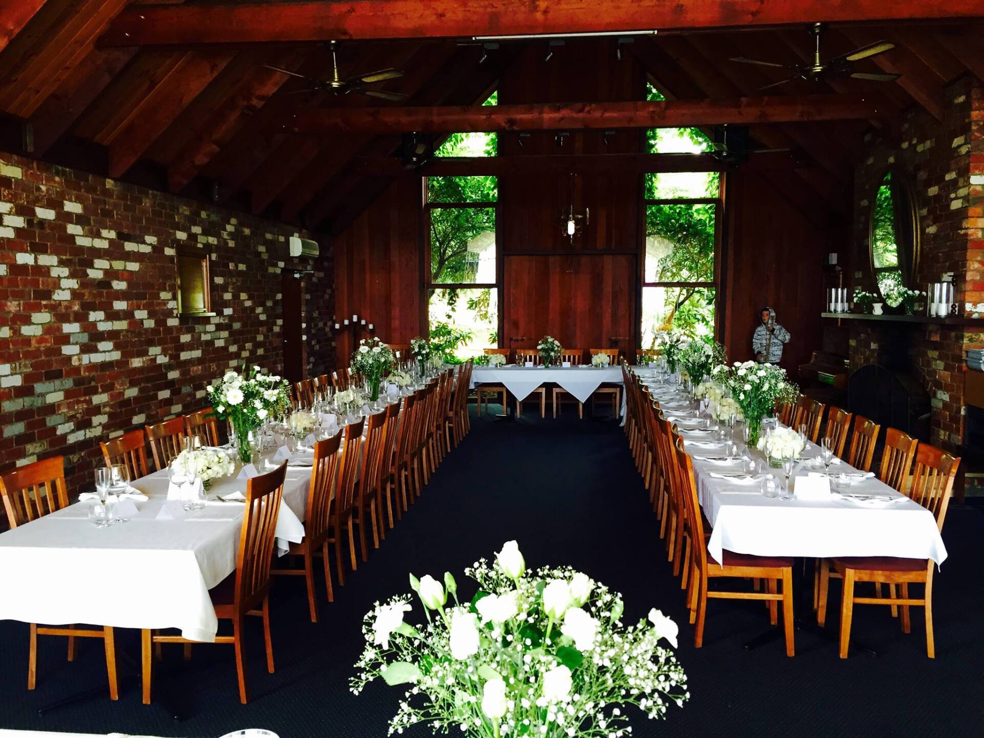 A large room with tables and chairs set up for a wedding reception